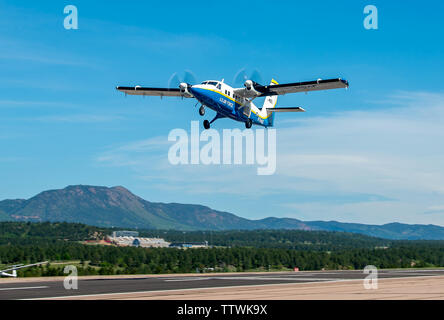 A UV-18 B Twin Otter aircraft takes off carrying cadets participating in the Airmanship 490 program (AM-490) on June 14, 2019 at the U.S. Air Force Academy airfield. AM-490, Basic Freefall Parachuting, is a training program where cadets must complete 5 parachute jumps to earn their jump wings following nearly 40 hours of ground training. It is the only certified program in the world where student’s very first jump is an unassisted freefall. (U.S. Air Force photo/Trevor Cokley) Stock Photo