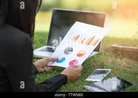 Relaxed Sales Managers Working Outdoor. Working Woman Showing Hand Market Report Charts.Planning New Strategy.Prepare Business Document. Using Marketi Stock Photo