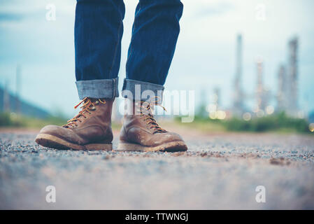 Engineer Wear Jeans And Brown Boots for Worker Security on Background of Refinery Stock Photo