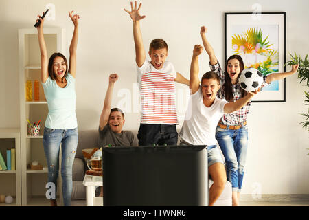 Young fans watching football match on TV Stock Photo