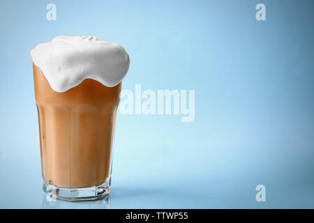 Glass of iced coffee with cream on blue background Stock Photo