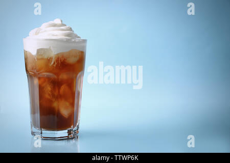 Glass of iced coffee with cream on blue background Stock Photo