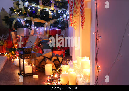 Christmas tree and colorful boxes with presents near fireplace Stock Photo