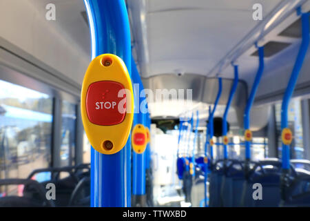 Stop button on a new, colorful city bus.