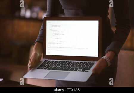 Woman holding laptop in cafe Stock Photo