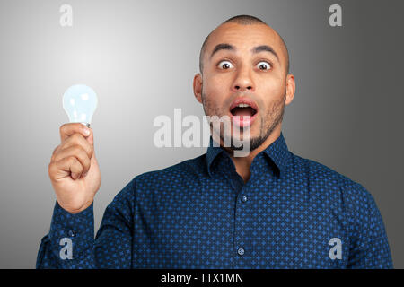Happy Young Businessman Holding Light Bulb Stock Photo