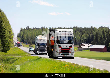 Humppila, Finland. May 31, 2019. Summer highway landscape with new Scania R500 truck hauling Hitachi Zaxis hydraulic excavator on trailer in traffic. Stock Photo