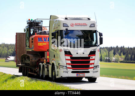 Humppila, Finland. May 31, 2019. New Scania R500 truck hauls Hitachi Zaxis 250 LC hydraulic excavator on trailer in highway traffic on day of summer. Stock Photo