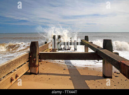 A view of the sea breaking against a wooden breakwater on the Norfolk coast at Cart Gap, Happisburgh, Norfolk, England, United Kingdom, Europe. Stock Photo
