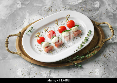 Set of delicious canapes on grey textured background Stock Photo