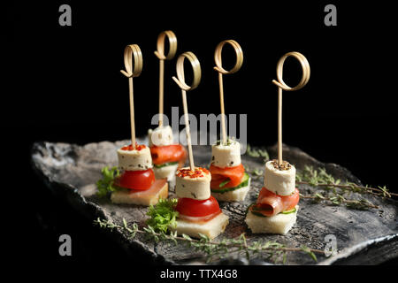 Delicious canapes on black background Stock Photo