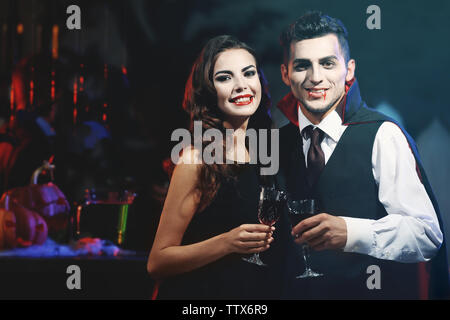 Young people dressed as vampires drinking cocktails at Halloween party Stock Photo