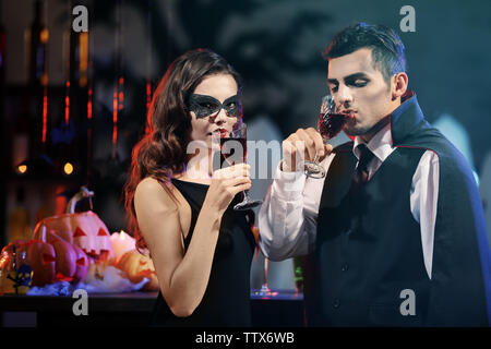 Young people dressed as vampires drinking cocktails at Halloween party Stock Photo