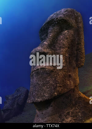 Close-up of the head of a gigantic idol dug into the ground against the backdrop of the night sky. Stock Photo