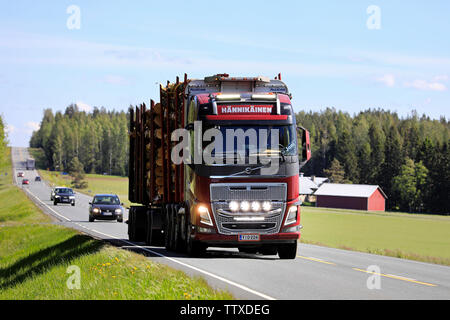 Humppila, Finland. May 31, 2019. Customised Volvo FH16 logging truck of Hannikainen with bright headlights briefly on hauls a log load along highway. Stock Photo