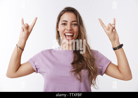 Enthusiastic optimistic happy charming caucasian 25s girl having fun enjoying awesome music concert relaxing friends smiling broadly showing tongue Stock Photo
