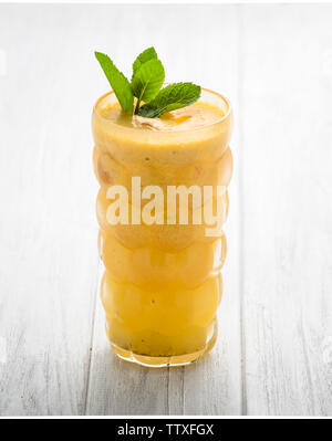 Orange and purple vegan smoothie is made from blueberry, sea buckthorn, coconut cream, nuts and chia on a white background. The concept of healthy sum Stock Photo