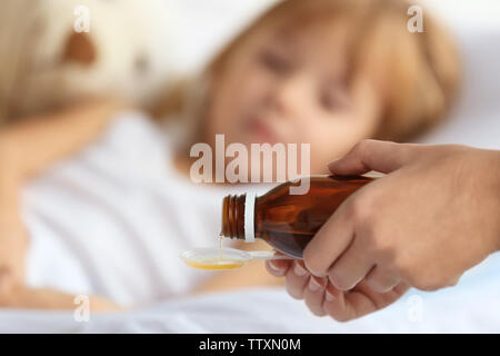 Woman pouring syrup for sick girl Stock Photo