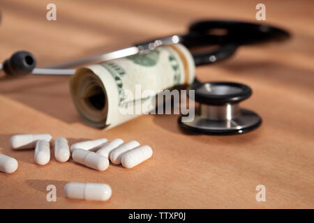 stethoscope, medical pills and US dollars close up on old paper