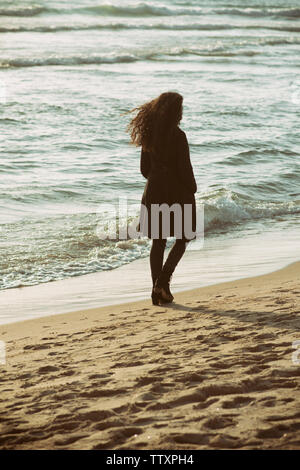 Young woman walking on the beach Stock Photo