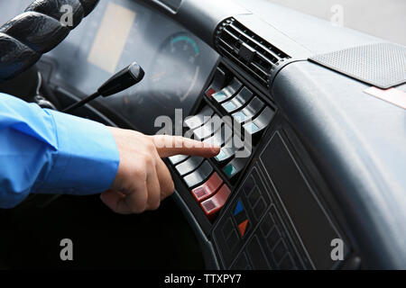 Bus driver  pushing button on panel Stock Photo