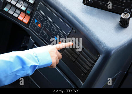 Bus driver  pushing button on panel Stock Photo