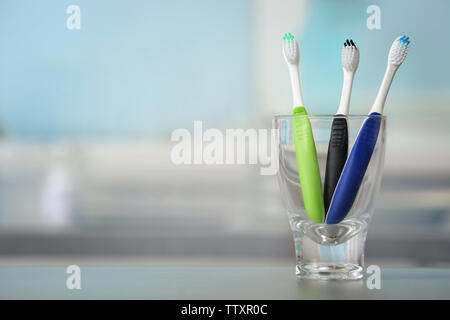 Toothbrushes in glass on blurred background Stock Photo