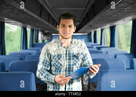 Conductor inside bus with clipboard Stock Photo