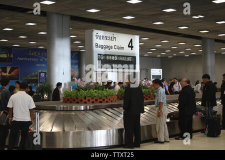 Passengers waiting for luggage at an airport carousel, Suvarnabhumi Airport, Bangkok, Thailand Stock Photo