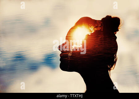 Power of mind concept. Silhouette of woman head with sun in head. Stock Photo