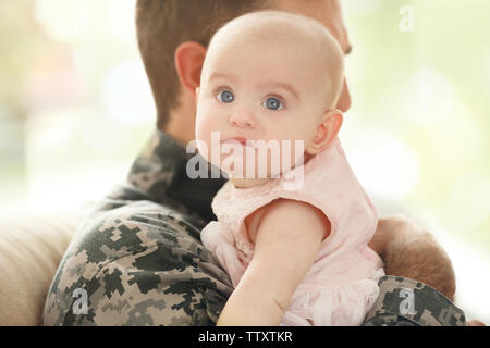 Military father holding his newborn baby Stock Photo