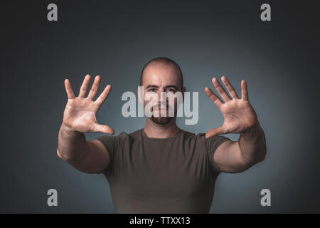 Portrait of a man with hands outstretched ahead of him. Selective focus studio shot Stock Photo
