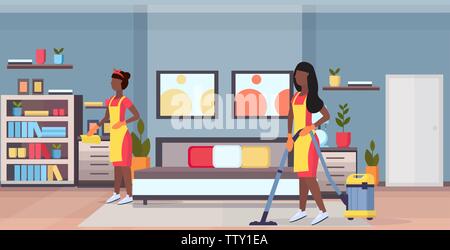 janitors women cleaners in uniform working together african american girls using vacuum cleaner and dust cloth cleaning service concept modern bedroom Stock Vector