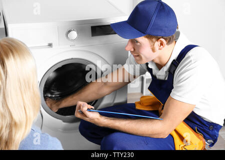 Plumber repairing washing machine Stock Photo