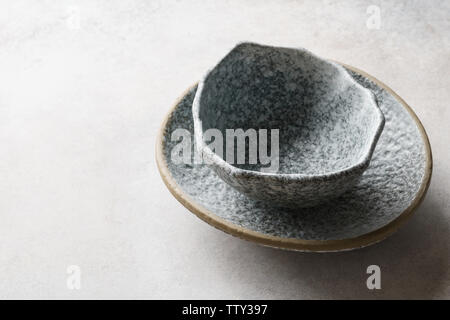 Empty ceramic bowls on concrete gray background. Handmade clay crockery concept. Stock Photo