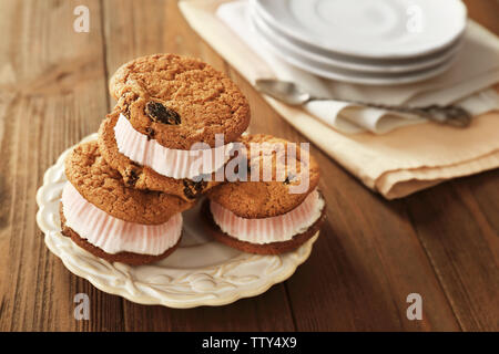 Ice cream cookie sandwiches on plate on wooden background Stock Photo
