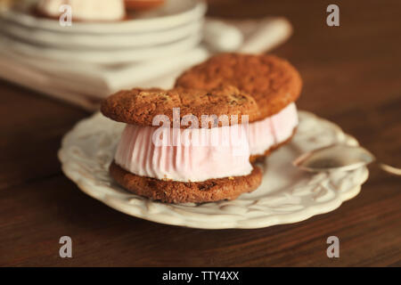 Ice cream cookie sandwiches on plate on wooden background Stock Photo