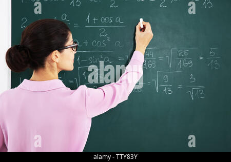 Young female teacher beside blackboard Stock Photo