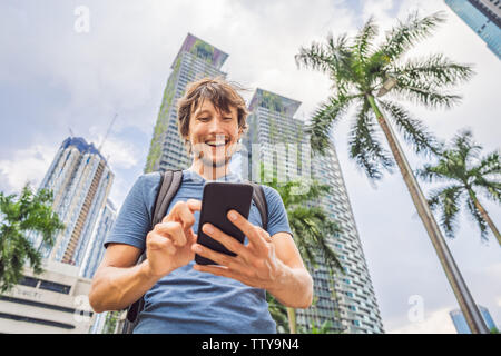 Man Tourist using navigation app on the mobile phone. Navigation map on a smartphone in a big city Stock Photo