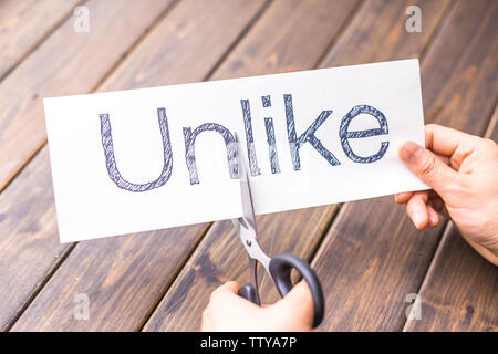 woman holds paper with word unlike in office Stock Photo