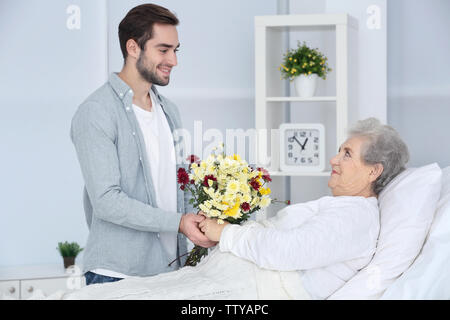 Grandson visiting grandmother in hospital Stock Photo