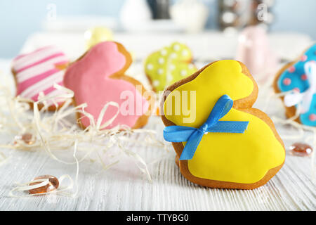 Creative rabbit shape Easter cookie and decorations on wooden table, closeup Stock Photo
