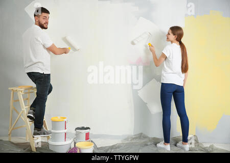 Young decorators painting wall in room Stock Photo