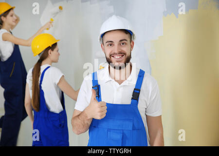 Young decorators painting wall in room Stock Photo
