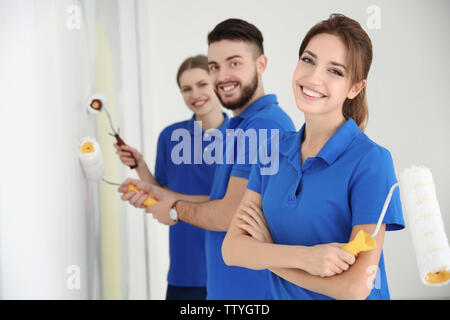 Young decorators painting wall in room Stock Photo