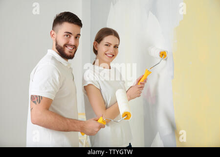 Young decorators painting wall in room Stock Photo