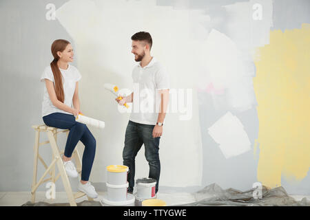 Young decorators painting wall in room Stock Photo