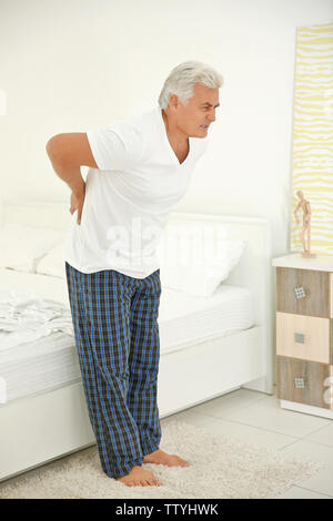 Senior gentleman suffering from pain in bedroom Stock Photo