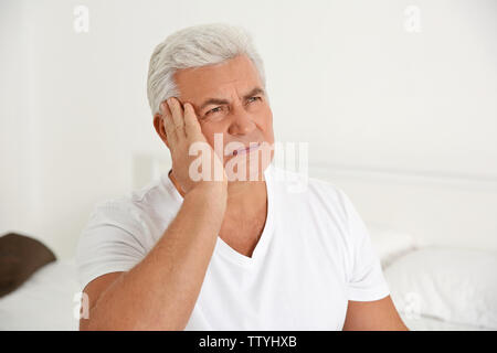 Senior gentleman suffering from pain in bedroom Stock Photo