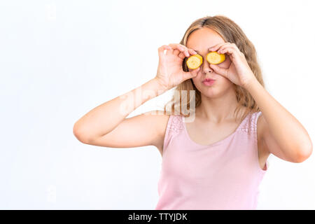 Pretty charming joyful attractive cheerful funny comic positive girl having two pieces of banana, closing two eyes, isolated on white background with Stock Photo